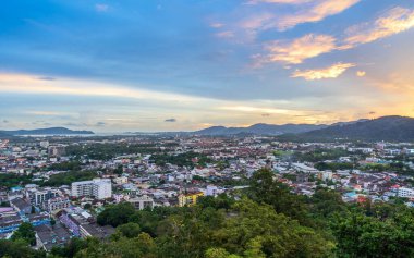 Phuket, Tayland, 9 Kasım 2024: Khao Rang tepesinden Phuket 'in havadan görünüşü, renkli bir akşam gökyüzü altında kentsel ve doğal manzarayı vurguluyor.