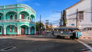 Phuket, Tayland - 11 Kasım 2024: Phuket Old Town 'da canlı bir turkuaz tarzı bina, güneşli bir günde Sino-Portekiz mimarisini ön plana çıkarıyor..