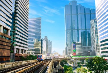 Bangkok, Tayland - 1 Ocak 2025: Sathorn Skywalk 'tan geçen BTS Skytrain, gökdelenler ve modern mimariyle çevrili, şehir ulaşımını ve iş dünyasını simgeliyor
