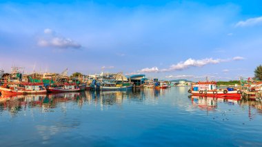 Rayong, Tayland-13 Nisan 2025: Pakistan veya Rayong Balıkçı Limanı 'na yanaşan renkli balıkçı tekneleri, canlı kıyı yaşamı ve deniz ürünleri ticareti gösteriyor.