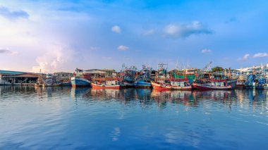 Rayong, Tayland-13 Nisan 2025: Pakistan veya Rayong Balıkçı Limanı 'na yanaşan renkli balıkçı tekneleri, canlı kıyı yaşamı ve deniz ürünleri ticareti gösteriyor.