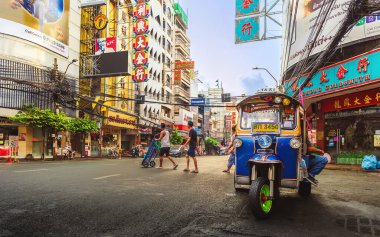 Yaowarat Yolu, Bangkok, Tayland - 15 Nisan 2024: Bangkok Çin Mahallesi 'nin göbeğinde tuk-tuk taksisi, yayalar ve renkli tabelalarla sabah sokak sahnesi