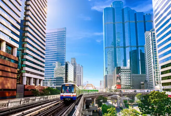 Bangkok, Tayland - 1 Ocak 2025: Sathorn Skywalk 'tan geçen BTS Skytrain, gökdelenler ve modern mimariyle çevrili, şehir ulaşımını ve iş dünyasını simgeliyor.