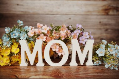 Anneler Günü 'nüz kutlu olsun. Ahşap arka planda çiçek buketi desenli.