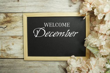 Tahtadaki tahta üzerine Aralık mesajı ve ahşap arka planda çiçek süslemesi