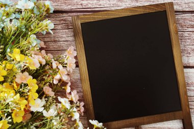 Tahta zemin üzerinde çiçek süsleme görünümlü metin iletisi için boş Chalkboard model alanı