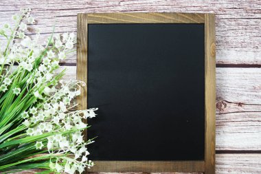 Tahta zemin üzerinde çiçek süsleme görünümlü metin iletisi için boş Chalkboard model alanı