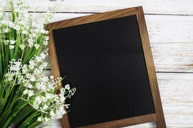 Tahta zemin üzerinde çiçek süsleme görünümlü metin iletisi için boş Chalkboard model alanı