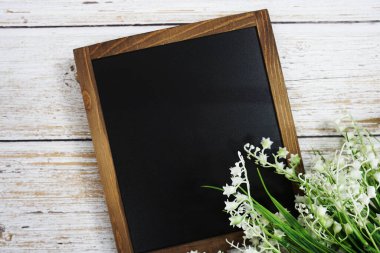 Tahta zemin üzerinde çiçek süsleme görünümlü metin iletisi için boş Chalkboard model alanı