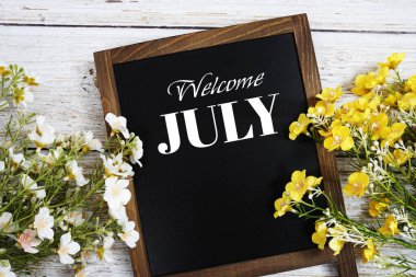 Tahta arka planda çiçek desenli Temmuz mesajına hoş geldiniz.