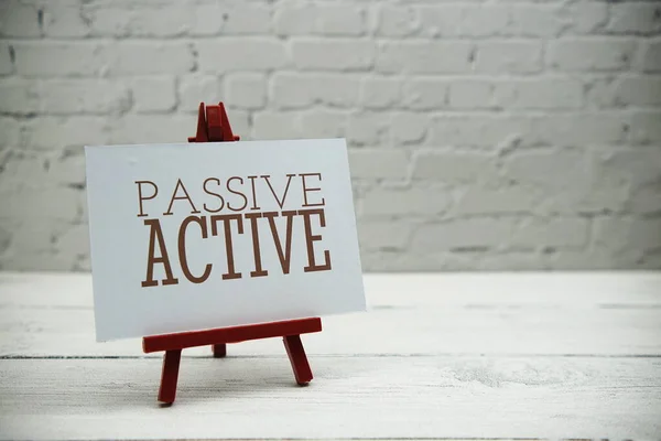 Passive Active text on white brick wall and wooden background