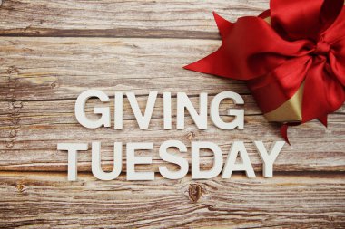 Tahta arka planda Salı alfabesi harfleri ve hediye kutusu vermek.