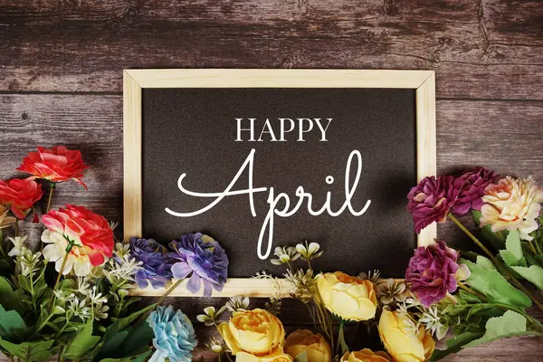 木製の背景に花の装飾と幸せな4月のテキストメッセージ — ストック写真