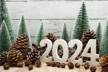 Yeni yılınız kutlu olsun. Noel ağacı ve ahşap arka planda çam kozalakları.