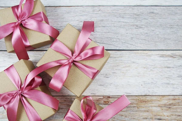 木制背景的粉红缎带礼品盒 — 图库照片