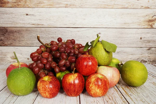 Różne Owoce Czerwonym Winogronem Czerwonym Jabłkiem Zieloną Pomarańczą Drewnianym Tle — Zdjęcie stockowe