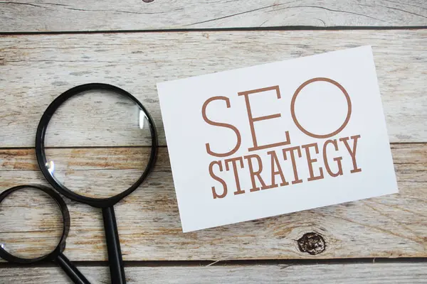 SEO strateji mesajı, tahta arka planda büyüteçle birlikte.