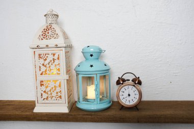 Ahşap raflarda Fener ve Vintage çalar saat