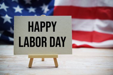 Ahşap zemin üzerinde ABD bayrağıyla Mutlu İşçi Bayramı mesajı