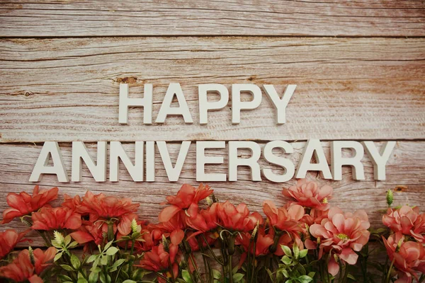 Happy Anniversary Alphabet Letters Flowers Frame Wooden Background — Fotografia de Stock