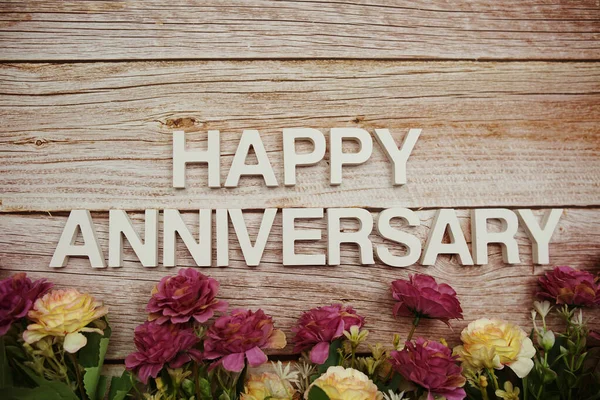 Happy Anniversary Alphabet Letters Flowers Frame Wooden Background — Foto Stock