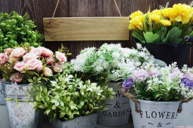 Alarmlı boş tahta tabela ve ahşap arka planda yapay bitki ev dekorasyonu.