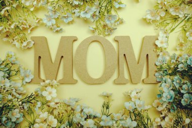 Anneler günü teması. Sarı arka planda anne mektupları ve çiçek süslemeleri.