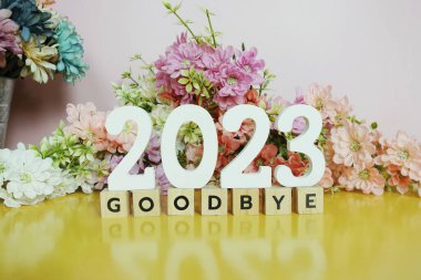 Elveda 2023 alfabe harfleri pembe ve sarı arka planda çiçek desenli