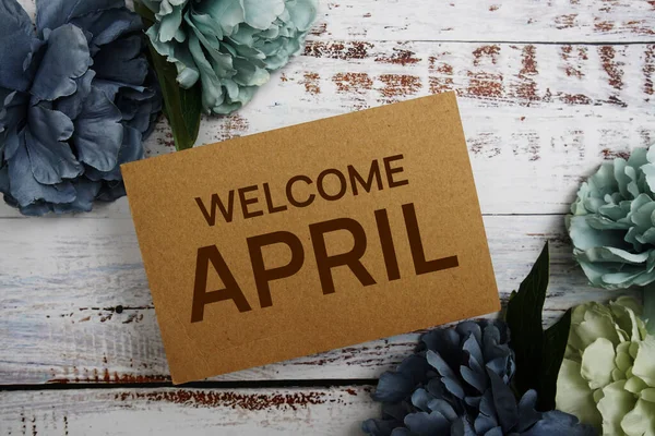 stock image Welcome April text message with flower decoration on wooden background