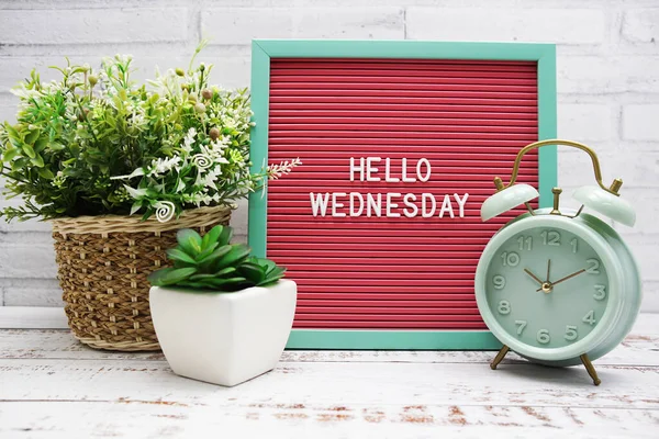 stock image Hello Wednesday text on Letter Board with alarm clcok and artificial plant decoration