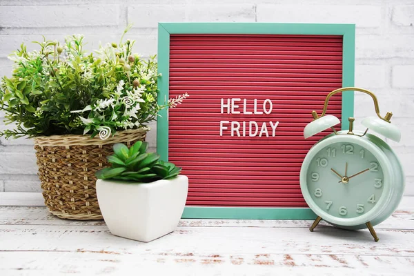 Stock image Hello Friday text on Letter Board with alarm clcok and artificial plant decoration