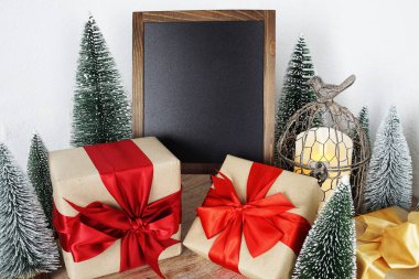 Gift boxes and Blank Blackboard wooden easel with Christmas tree and LED candle light