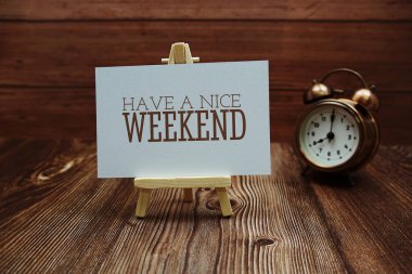 Have a nice weekend text on paper card on wooden background clipart