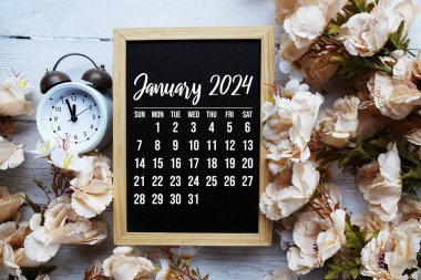Ahşap arka planda çiçek buketi süslemesi olan Ocak 2024 aylık takvim
