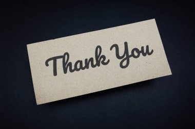 Siyah arkaplanda kağıt işçiliği üst görünümü üzerine yazılan metin mesajı için teşekkürler