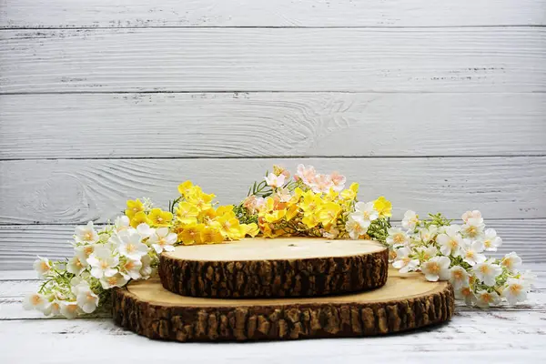 Wooden podium stand for product display with flower decoration on wooden background