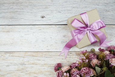 Ahşap arka planda pembe kurdeleli hediye kutusu