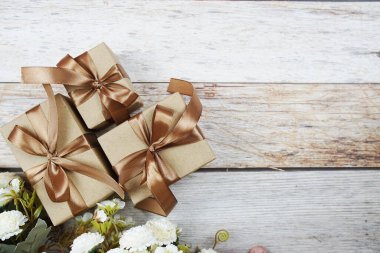 Tahta arka planda altın kurdeleli hediye kutuları