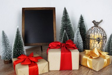 Gift boxes and Blank Blackboard wooden easel with Christmas tree and LED candle light