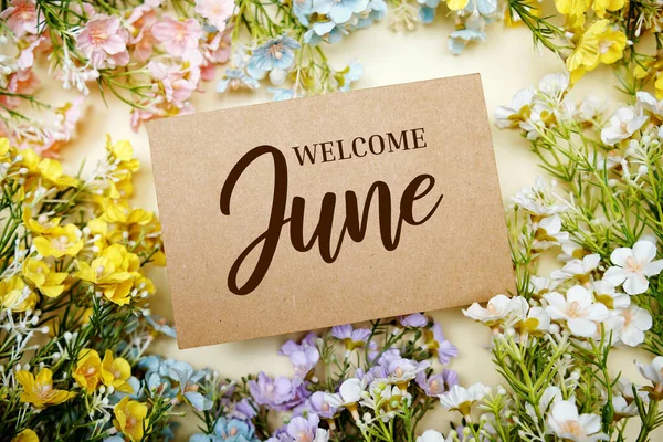 黄色の背景に花の装飾を施した歓迎の6月のテキストメッセージ ストック写真