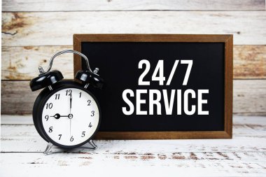 24 Saat 7 Gün Servis Mesajı ve ahşap arka planda alarm tıklaması