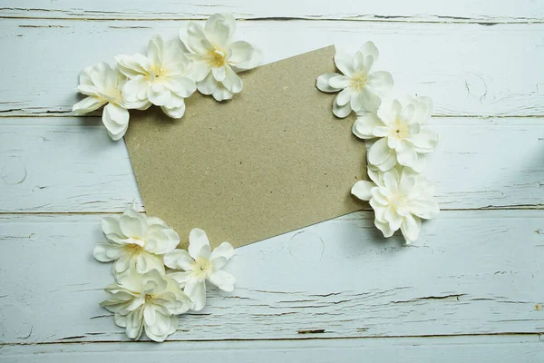 Empty paper craft with flower bouquet Top view on wooden background
