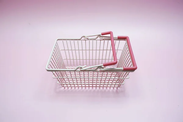 Pink empty shopping basket with space copy on pink background