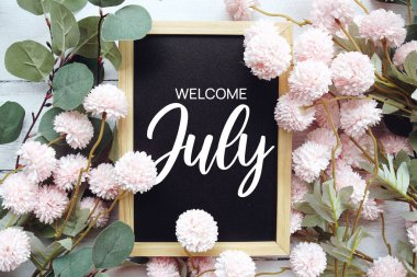 Tahta arka planda çiçek desenli Temmuz mesajına hoş geldiniz.