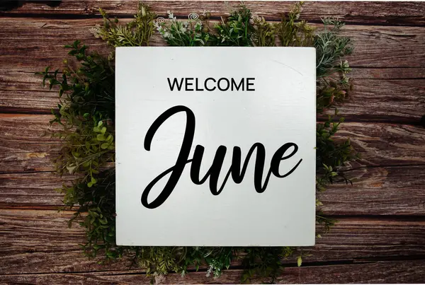 Ahşap arkaplanda yeşil yaprak süslemesiyle Haziran mesajına hoş geldiniz