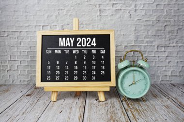 Mayıs 2024 Ahşap zemin üzerinde aylık takvim ve alarm saati
