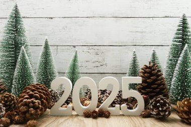 Yeni yılınız kutlu olsun. Noel ağacı ve ahşap arka planda çam kozalakları.