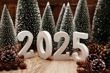 Yeni yılınız kutlu olsun. Ahşap arka planda Noel ağacı ve çam kozalağı süslemesi var.
