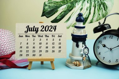 Yaz aksesuarları ahşap arka planda olan Temmuz 2024 aylık takvim