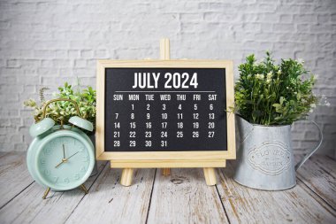 Temmuz 2024 Aylık takvim sehpada ahşap arka planda duruyor
